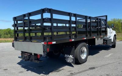 How does using a flatbed truck with a dovetail streamline heavy equipment transport and loading